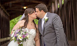 Miranda Brown kisses her husband Andrew on their wedding day as they stand on a bridge